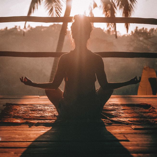 Meditation for Chakra Balancing woman performing meditation at sunset